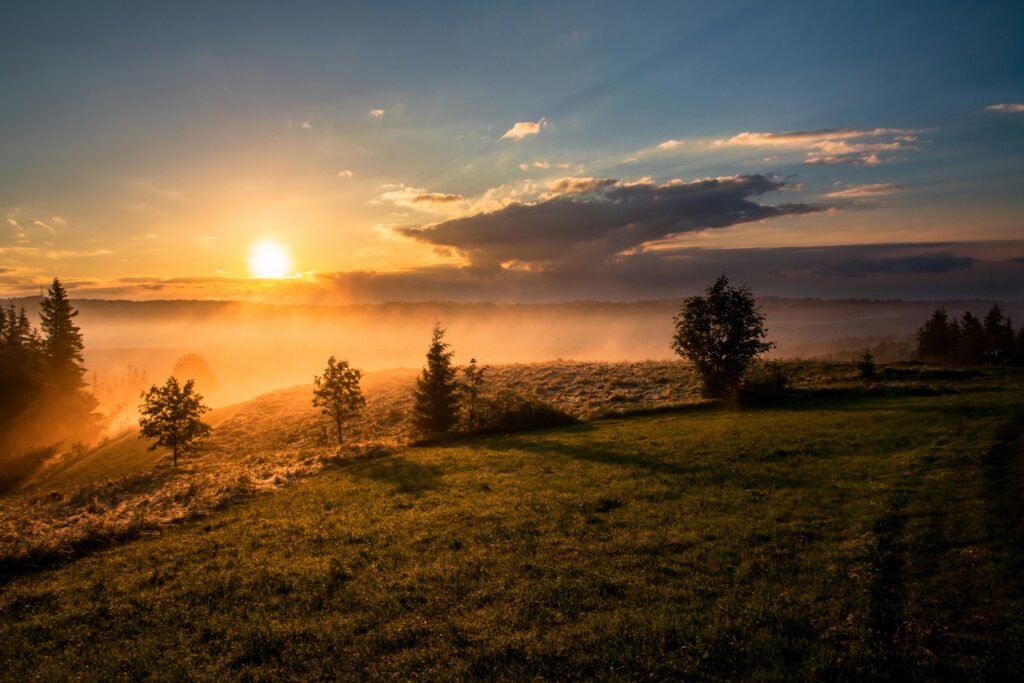 Sonnenaufgang über weiter Landschaft als Symbol für Integration nach einem energetischen Clearing